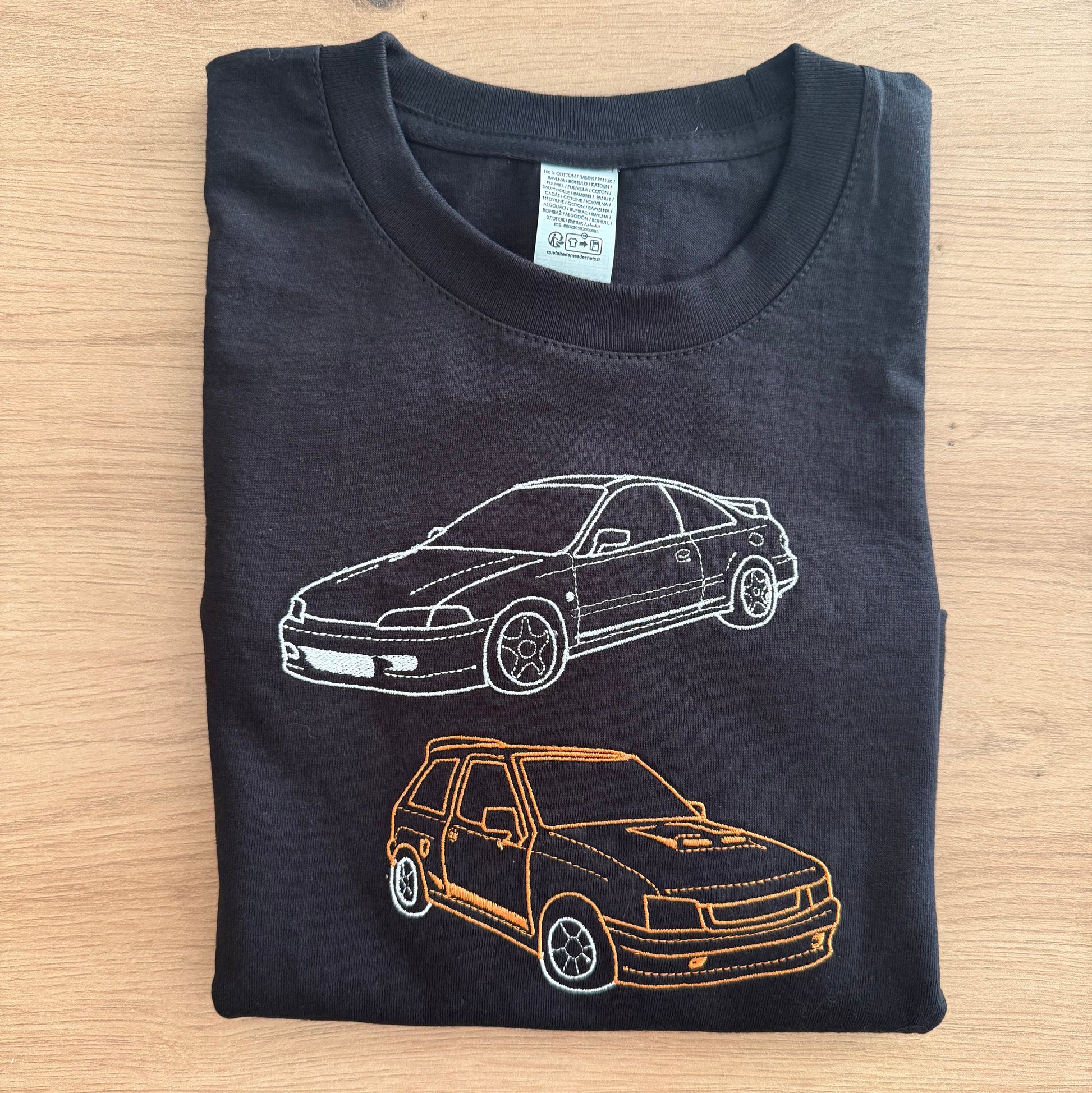Black t-shirt with car designs on a wooden surface